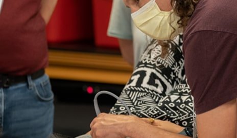 A man wearing protective gear holds a baby, emphasizing a caring and safe environment for the child.